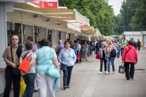 People walk by the booths of the Madrid Book Fair on a cloudy Monday morning on June 10, 2015 in Retiro Park. The fair, which started on May 29 and ended June 14, features 4,071 exhibitors and 2,600 authors.